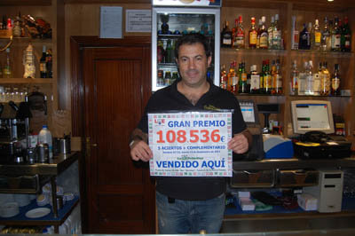 Javier Cano muestra sonriente el cartel con el importe del premio. (Foto: R.R.)