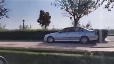Un coche circula a plena luz del día por la zona peatonal de la Ronda Sur junto al río Tajo
