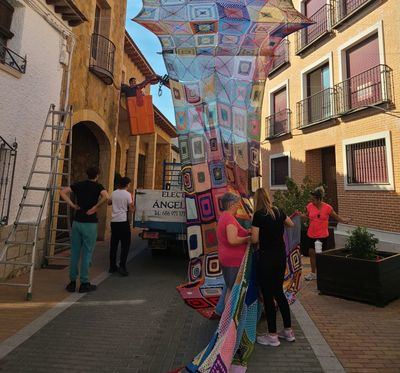Vecinas de Santa Olalla llenan de color y sombra su calle con un toldo artesanal de ganchillo